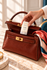 Musc Blanc Ivoire 35 ml glissé dans un sac à main en cuir