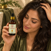 Soin aux 10 huiles capillaires tenu pendant un rituel cheveux